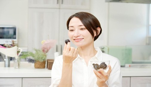 Asian Woman Eating Prunes
